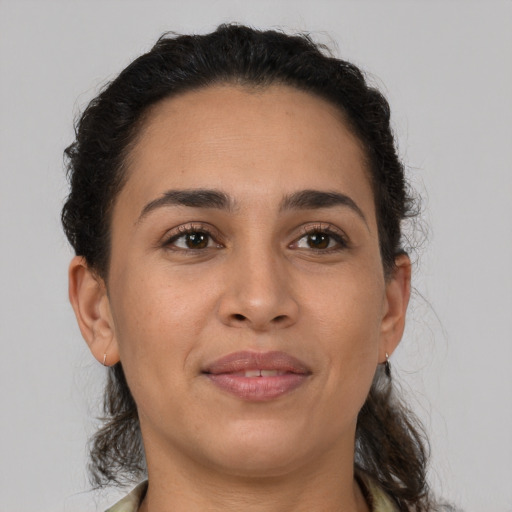 Joyful latino young-adult female with medium  brown hair and brown eyes