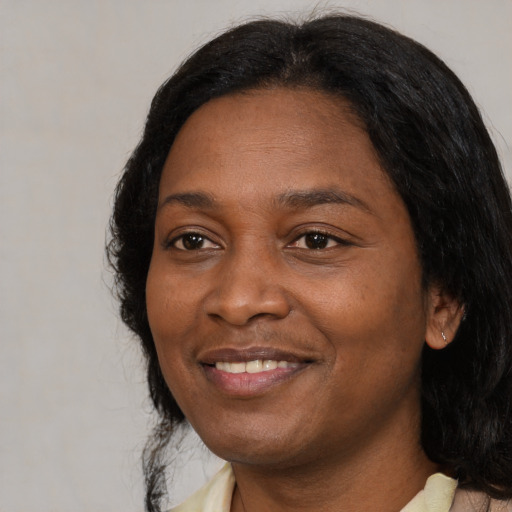 Joyful black adult female with medium  black hair and brown eyes