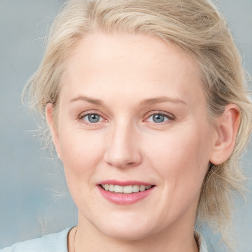 Joyful white adult female with medium  brown hair and blue eyes