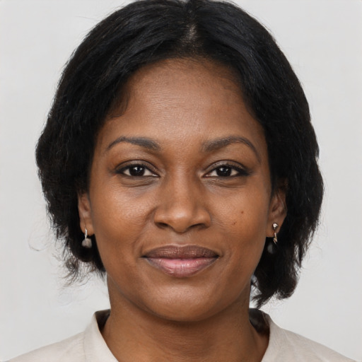 Joyful black young-adult female with medium  brown hair and brown eyes