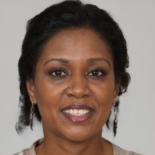 Joyful black adult female with medium  brown hair and brown eyes