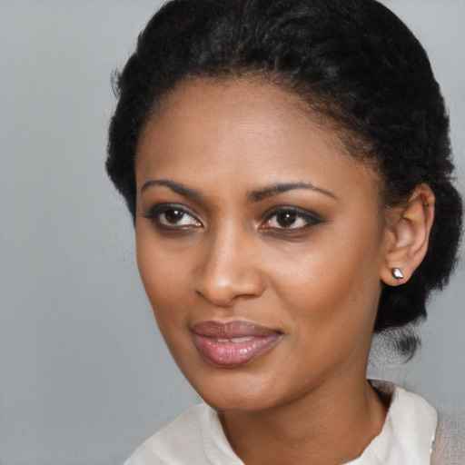 Joyful black young-adult female with short  black hair and brown eyes