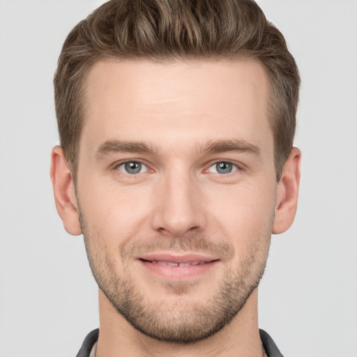 Joyful white young-adult male with short  brown hair and grey eyes