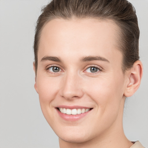 Joyful white young-adult female with short  brown hair and grey eyes