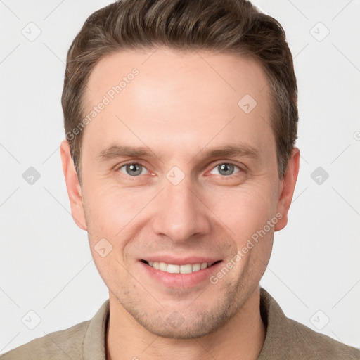 Joyful white young-adult male with short  brown hair and grey eyes