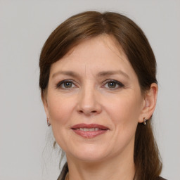 Joyful white adult female with medium  brown hair and grey eyes