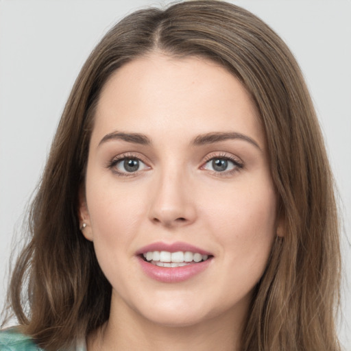 Joyful white young-adult female with long  brown hair and grey eyes