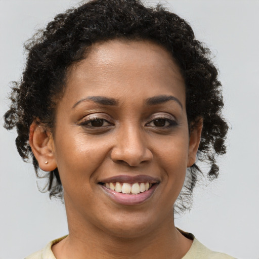Joyful black young-adult female with short  brown hair and brown eyes