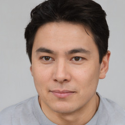 Joyful asian young-adult male with short  brown hair and brown eyes