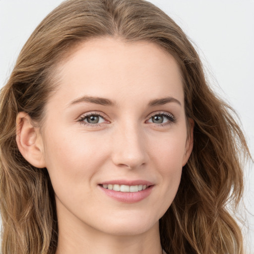 Joyful white young-adult female with long  brown hair and blue eyes