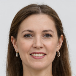 Joyful white adult female with long  brown hair and grey eyes