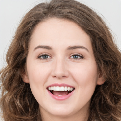 Joyful white young-adult female with long  brown hair and green eyes