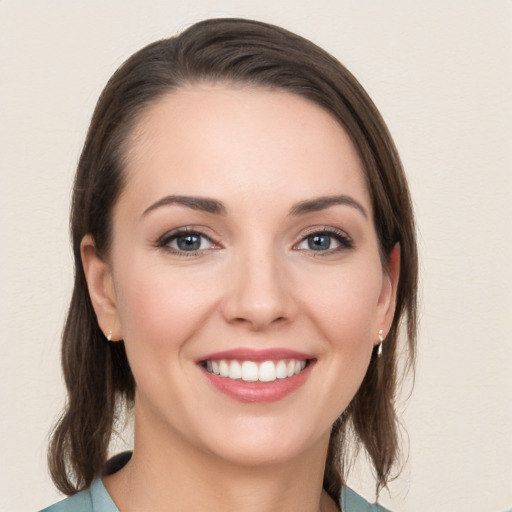 Joyful white young-adult female with medium  brown hair and grey eyes