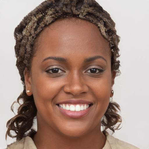 Joyful black young-adult female with long  brown hair and brown eyes