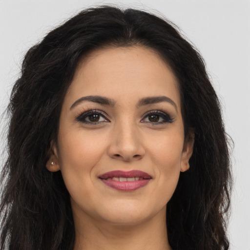 Joyful latino young-adult female with long  brown hair and brown eyes