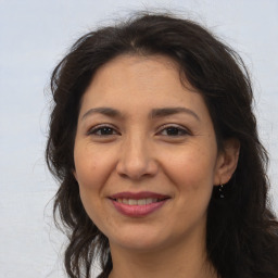 Joyful white adult female with long  brown hair and brown eyes