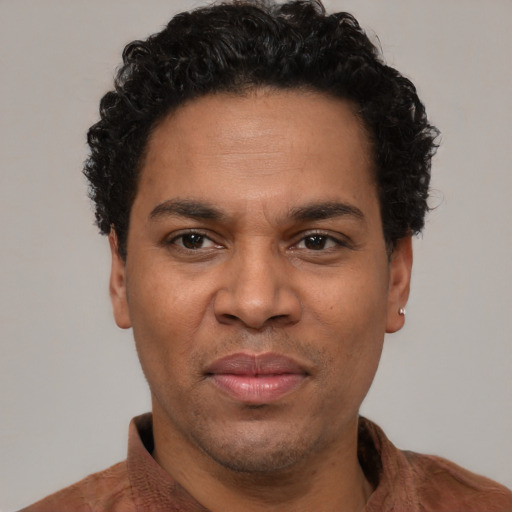 Joyful latino adult male with short  brown hair and brown eyes