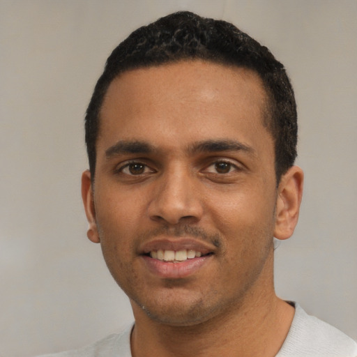 Joyful black young-adult male with short  black hair and brown eyes