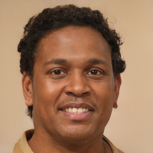 Joyful black young-adult male with short  brown hair and brown eyes