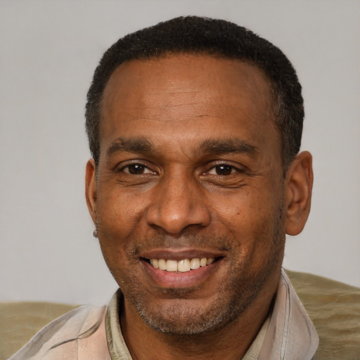 Joyful black adult male with short  brown hair and brown eyes