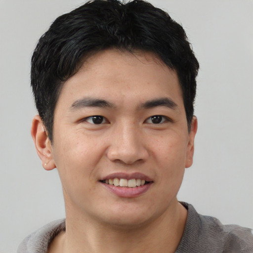 Joyful asian young-adult male with short  black hair and brown eyes