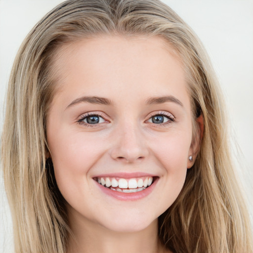 Joyful white young-adult female with long  brown hair and blue eyes