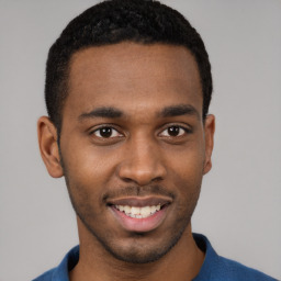 Joyful black young-adult male with short  brown hair and brown eyes