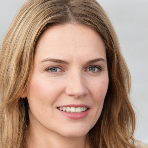 Joyful white young-adult female with long  brown hair and green eyes