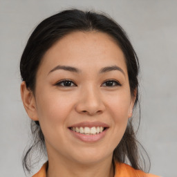 Joyful asian young-adult female with long  brown hair and brown eyes