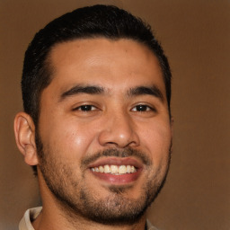 Joyful latino young-adult male with short  brown hair and brown eyes