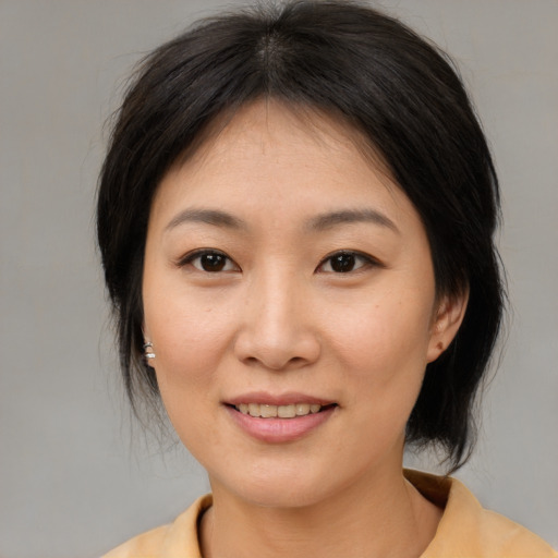 Joyful asian young-adult female with medium  brown hair and brown eyes