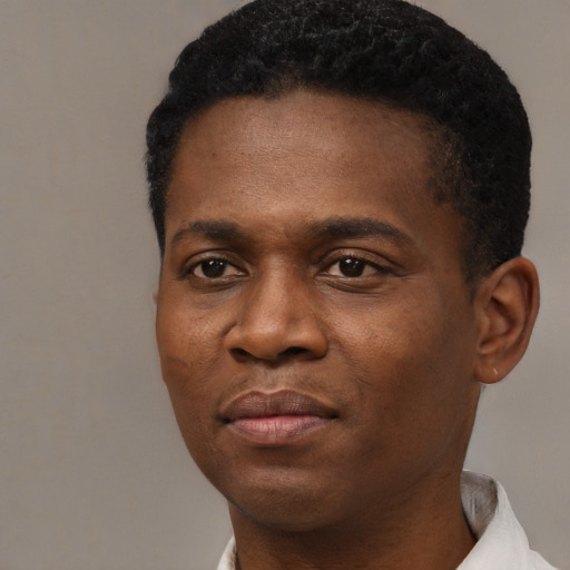 Joyful black young-adult male with short  black hair and brown eyes