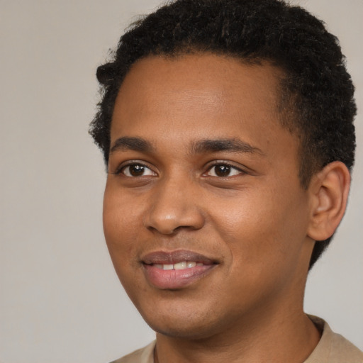 Joyful black young-adult male with short  brown hair and brown eyes