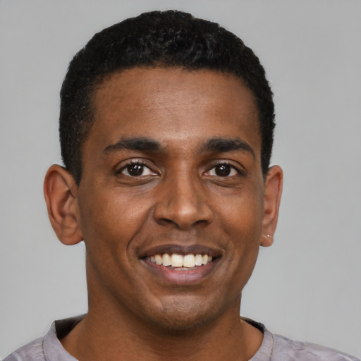 Joyful black young-adult male with short  black hair and brown eyes
