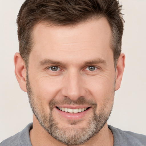 Joyful white adult male with short  brown hair and brown eyes