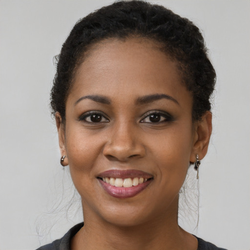 Joyful black young-adult female with long  brown hair and brown eyes