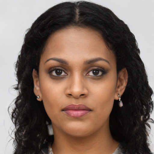 Joyful black young-adult female with long  black hair and brown eyes