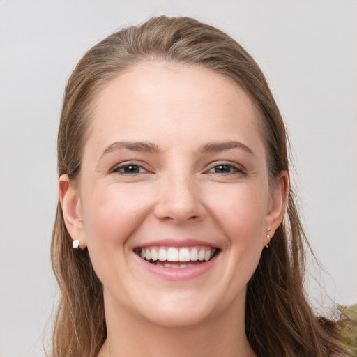 Joyful white young-adult female with long  brown hair and grey eyes