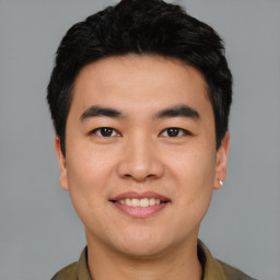 Joyful asian young-adult male with short  black hair and brown eyes