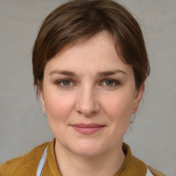 Joyful white young-adult female with medium  brown hair and grey eyes