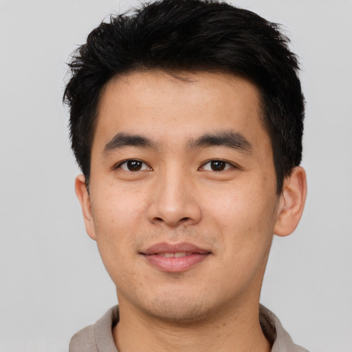 Joyful asian young-adult male with short  black hair and brown eyes