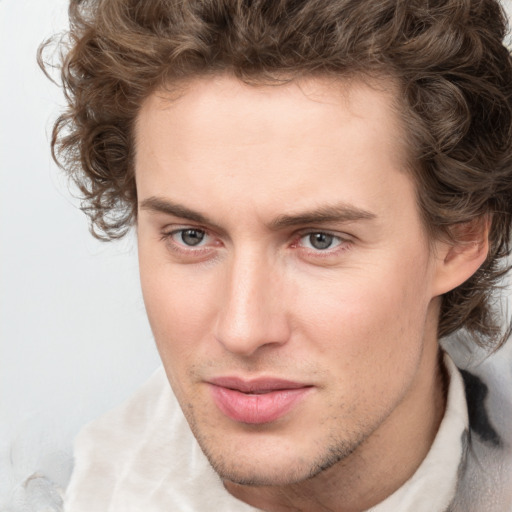 Joyful white young-adult male with short  brown hair and blue eyes