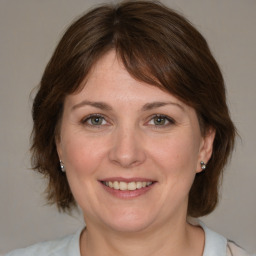 Joyful white adult female with medium  brown hair and grey eyes