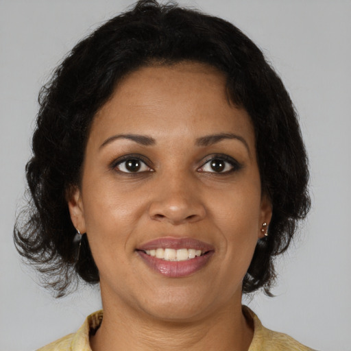 Joyful black young-adult female with medium  brown hair and brown eyes