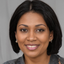 Joyful black young-adult female with medium  brown hair and brown eyes