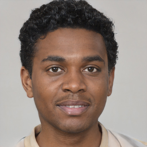 Joyful black young-adult male with short  brown hair and brown eyes