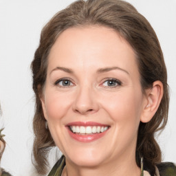 Joyful white adult female with medium  brown hair and grey eyes