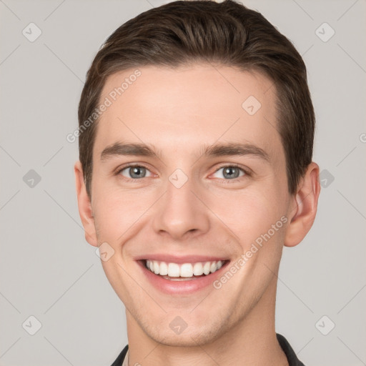 Joyful white young-adult male with short  brown hair and grey eyes