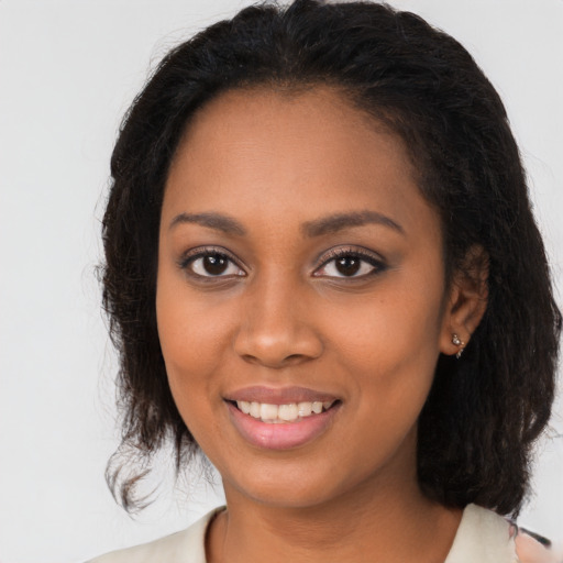 Joyful black young-adult female with medium  brown hair and brown eyes