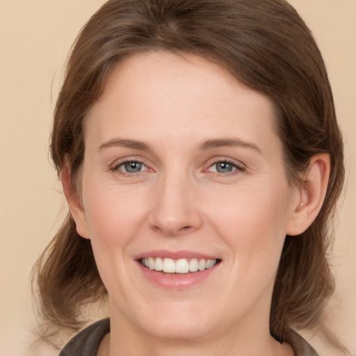 Joyful white young-adult female with medium  brown hair and grey eyes